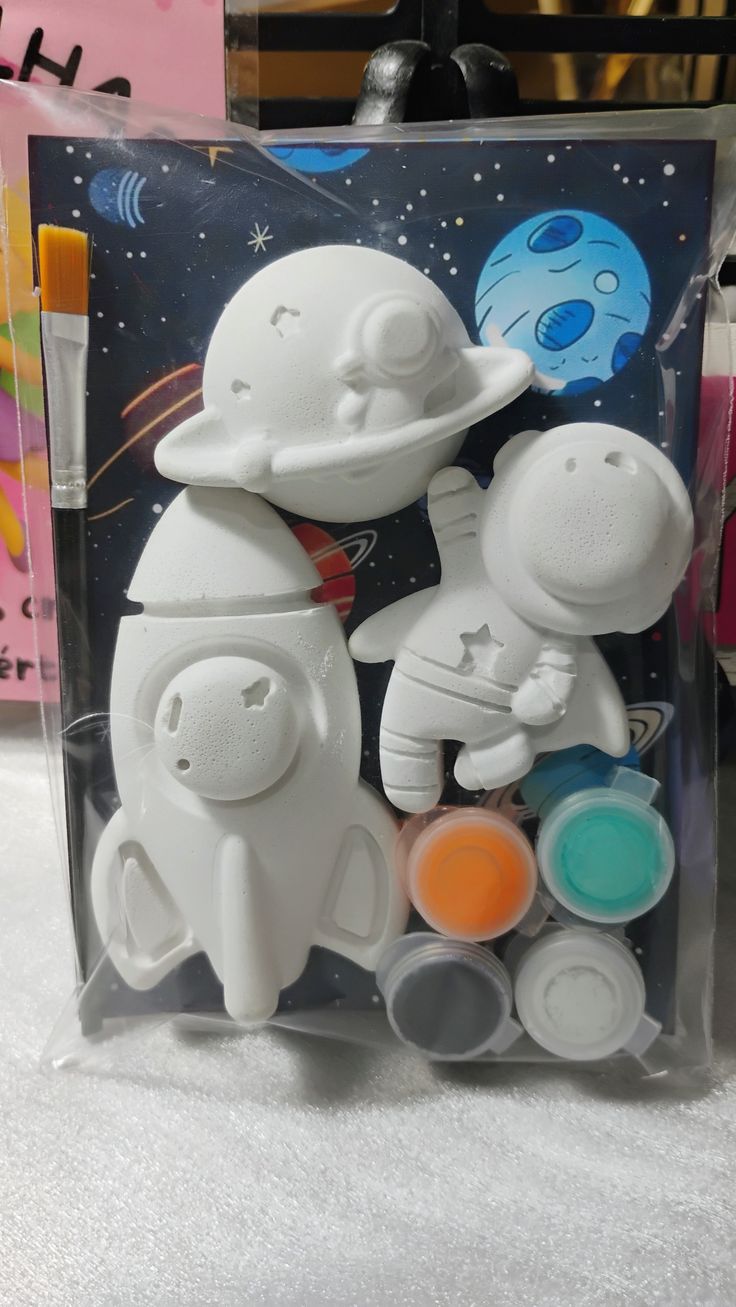 Kit tema espaço embalado com foguete, astronauta, planeta, pincel e potinhos de tinta